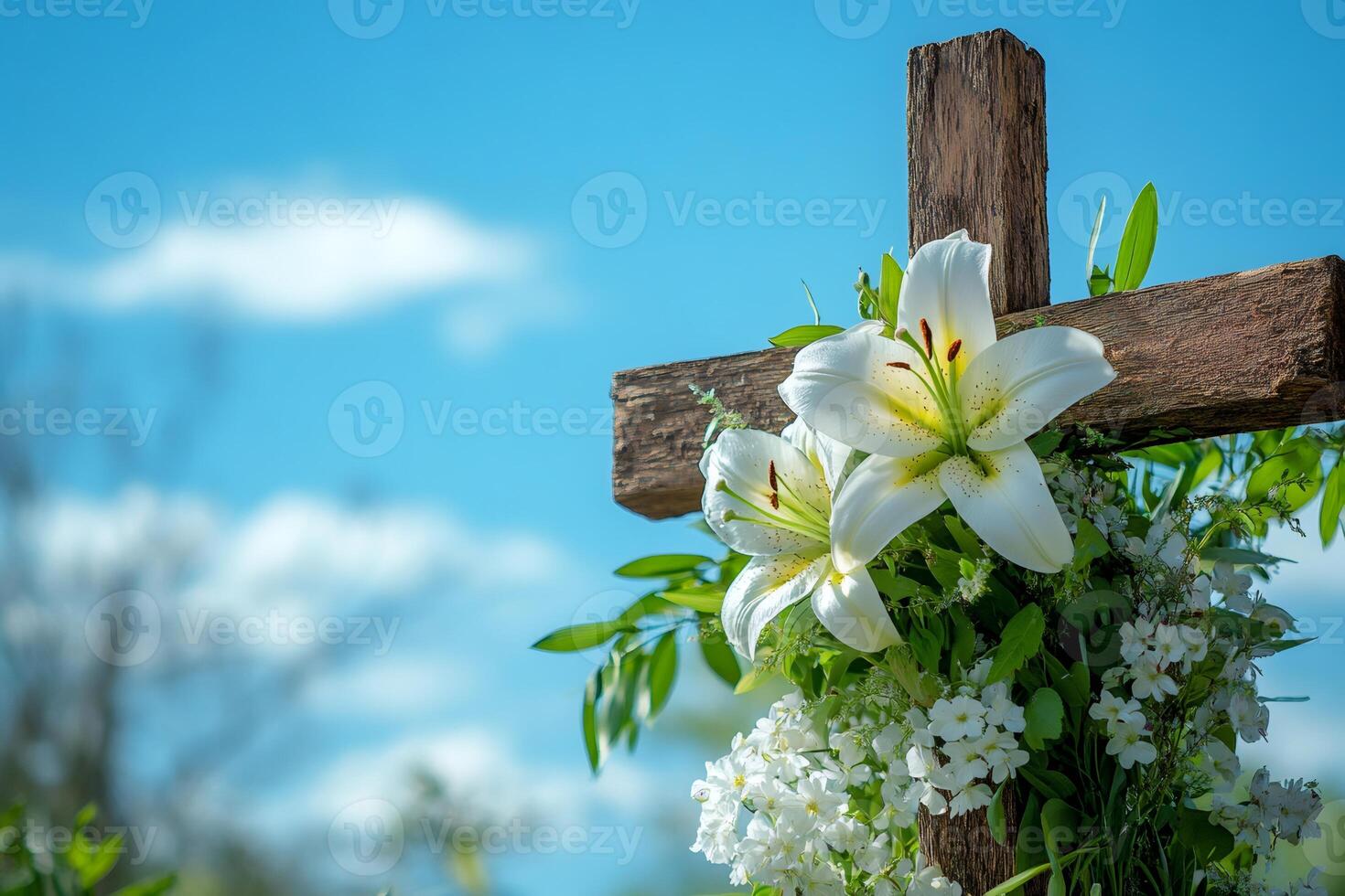 White lilies adorning wooden cross against blue sky photo
