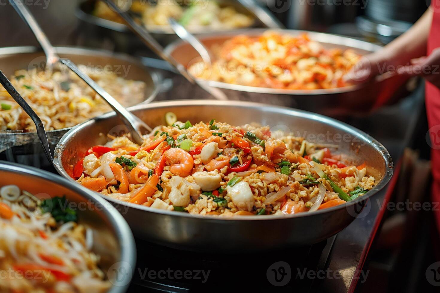 Chef preparing asian noodles with shrimps and vegetables in wok pan photo