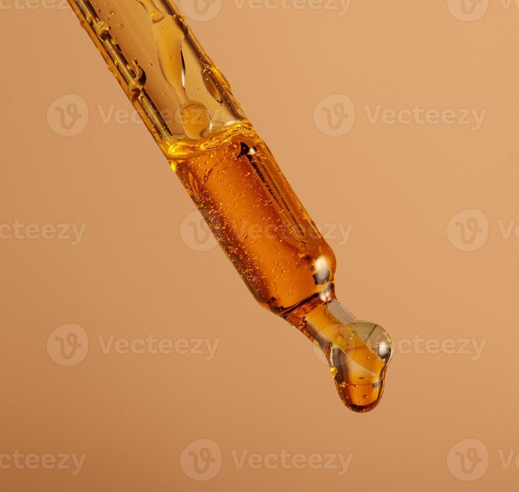 macro photo of a pipette filled with brown oil drop