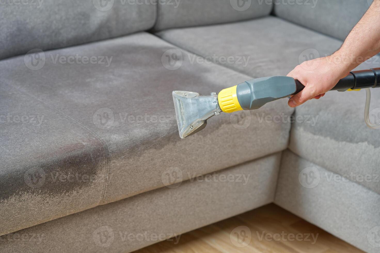Sofa chemical cleaning with professionally extraction method. Wet textile sofa cleaning. home cleaning service. cleaning sofa with washing suction cleaner closeup. photo