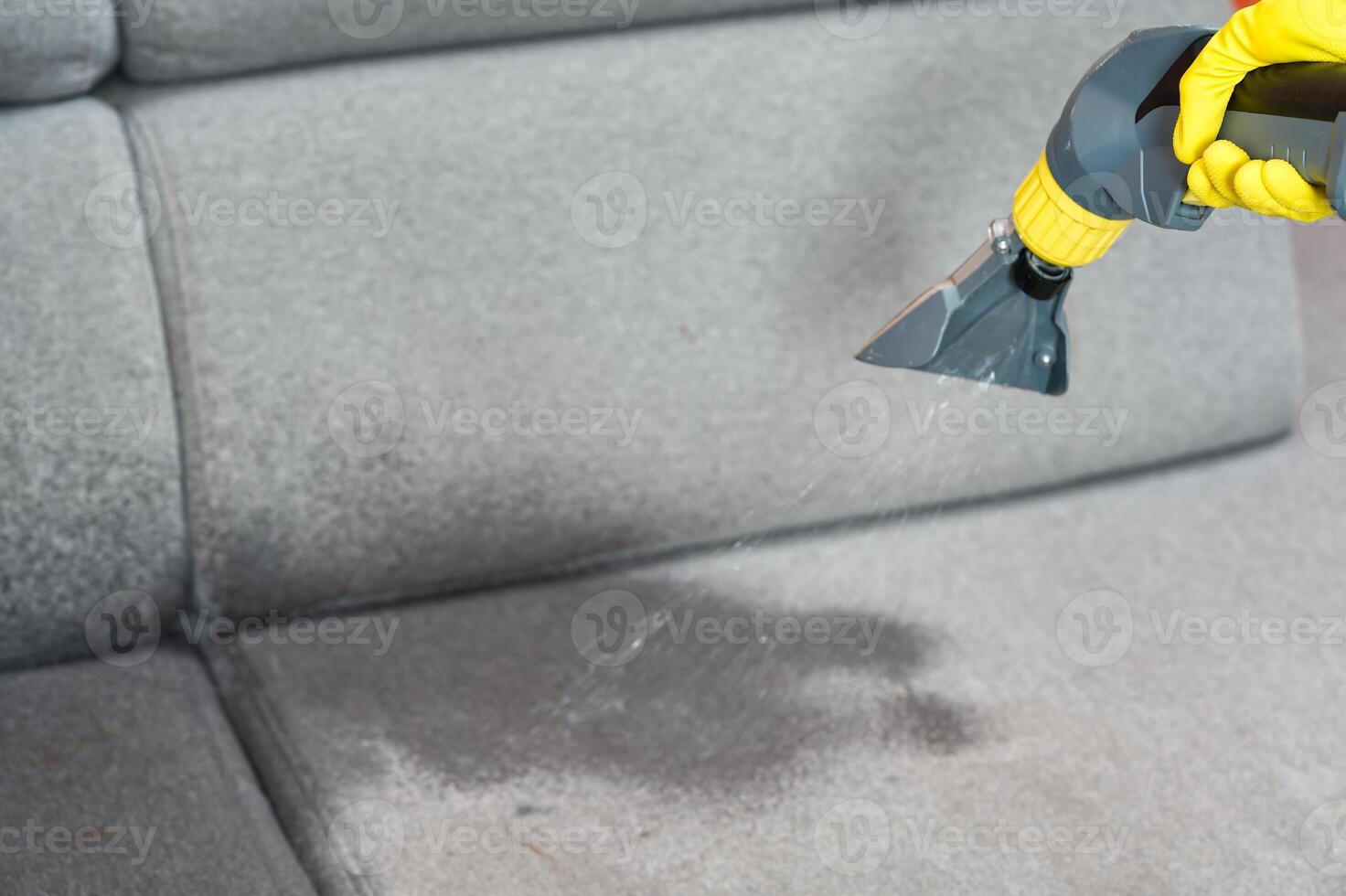 Sofa chemical cleaning with professionally extraction method. Wet textile sofa cleaning. home cleaning service. cleaning sofa with washing suction cleaner closeup. photo