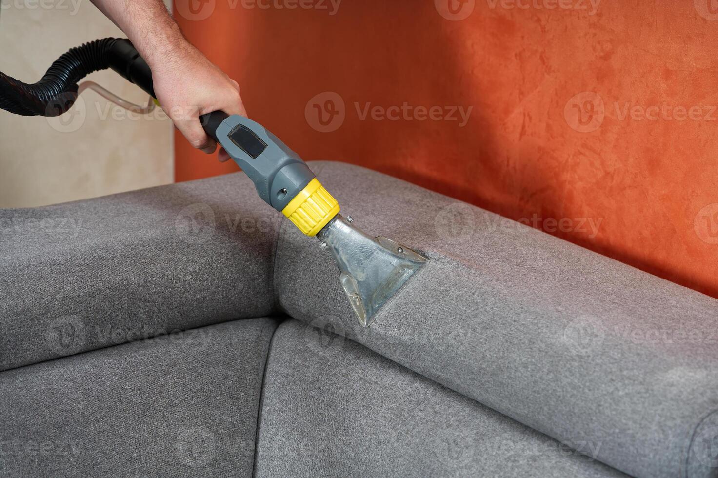 Sofa chemical cleaning with professionally extraction method. Wet textile sofa cleaning. home cleaning service. cleaning sofa with washing suction cleaner closeup. photo