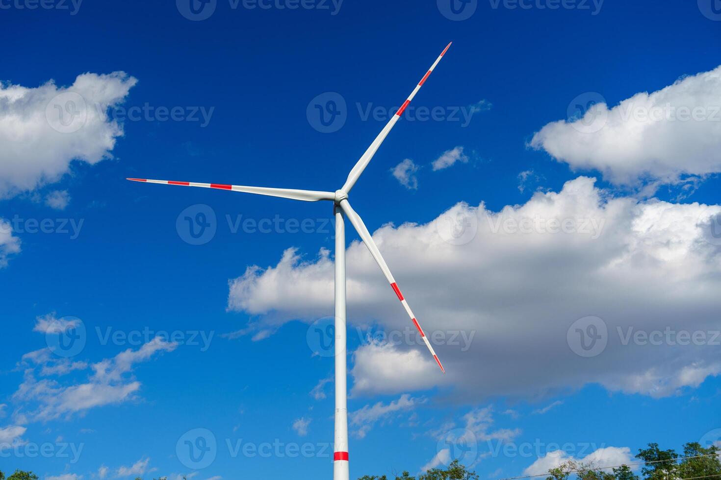 Wind turbine generating clean renewable energy on a blue sky background. photo
