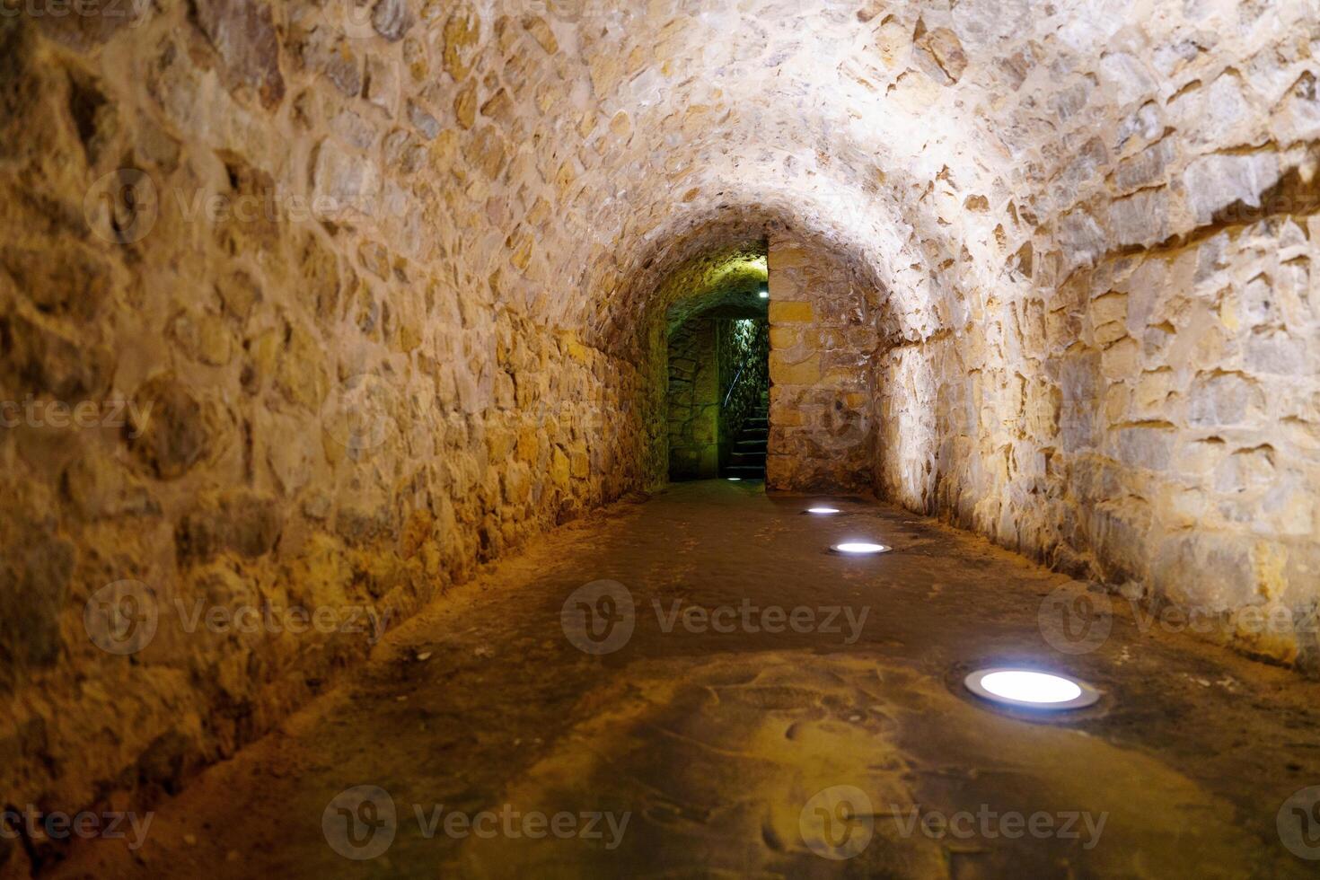 Mysterious Dungeon Corridor with Arched Stone Walls and Dark Atmosphere photo
