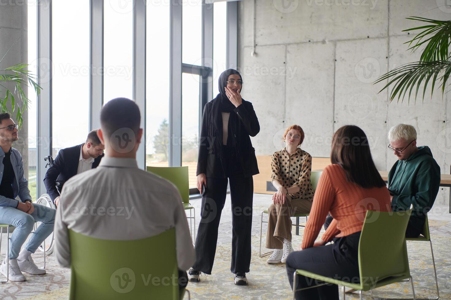 Corporate business team meeting with a manager or coach. Group of happy diverse, multiracial people sitting in a circle photo