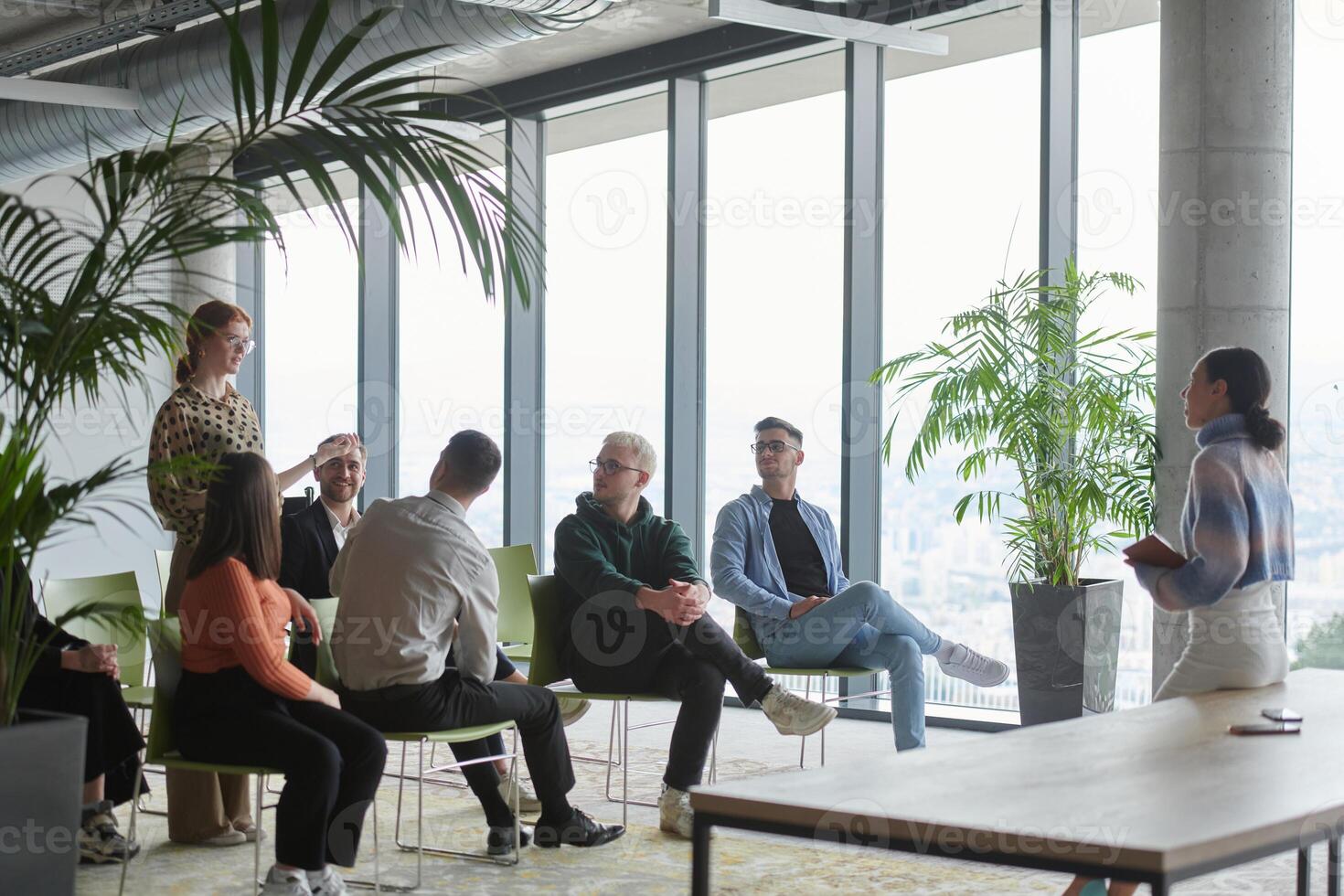 A diverse group of business professionals sits attentively in a modern office, actively participating in a training session led by an instructor, focusing on the latest technological advancements in photo