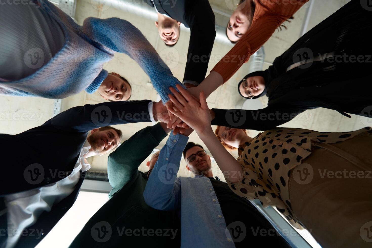 A group of business professionals, captured from a low angle, holding hands to symbolize unity and teamwork. photo