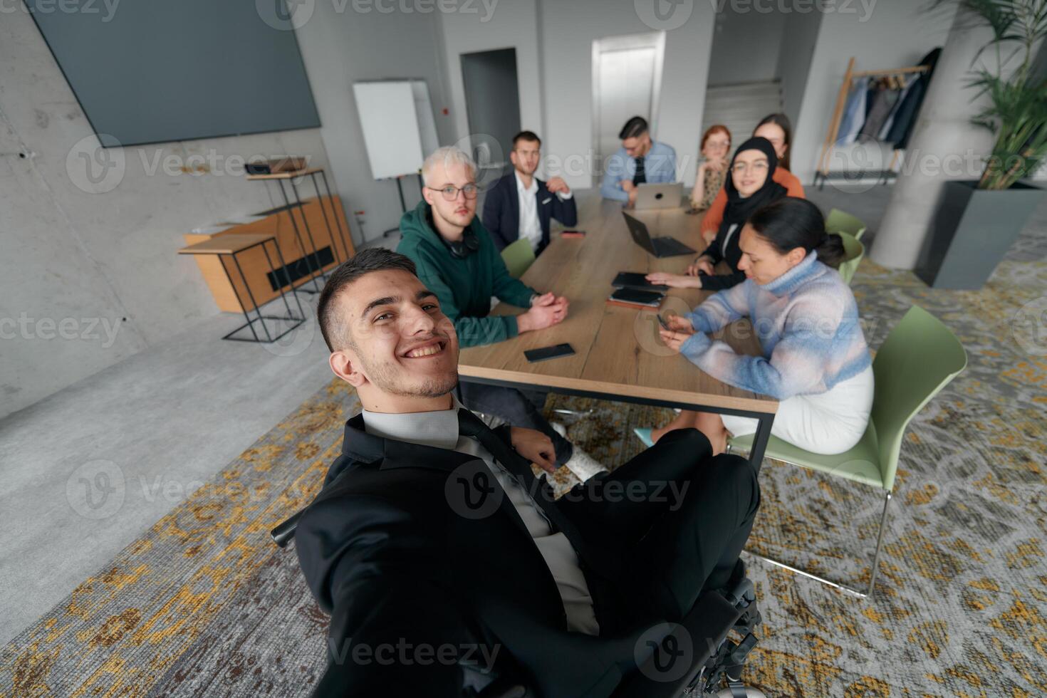 A group of business professionals taking a selfie during a break in an office meeting, capturing a moment of teamwork and collaboration in a modern workplace photo