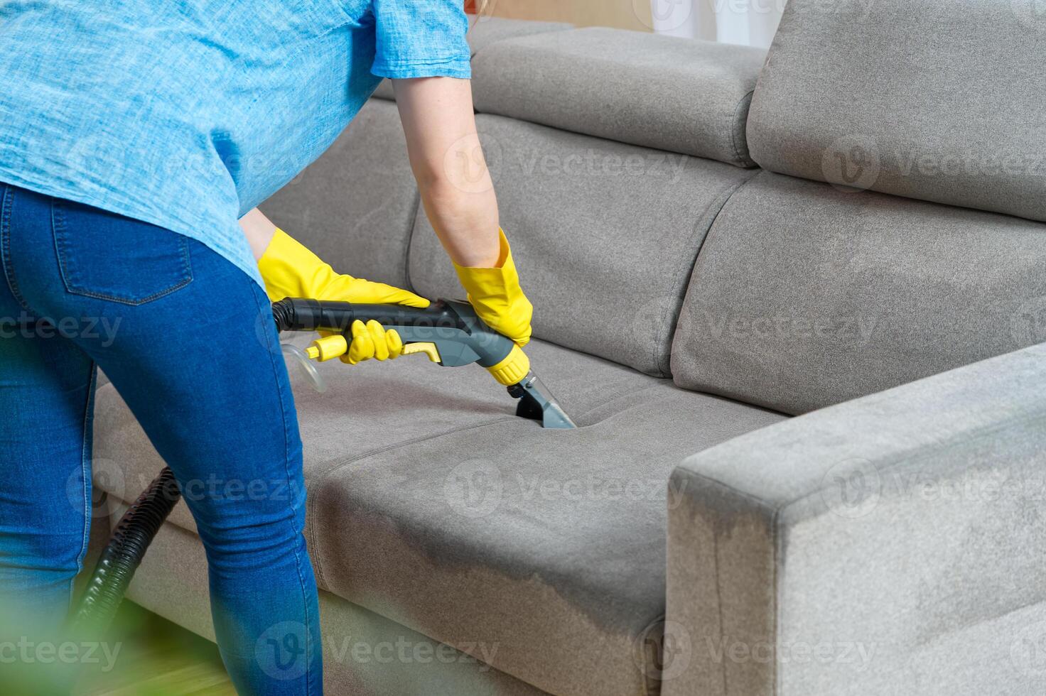 Sofa chemical cleaning with professionally extraction method. Wet textile sofa cleaning. home cleaning service. cleaning sofa with washing suction cleaner closeup. photo