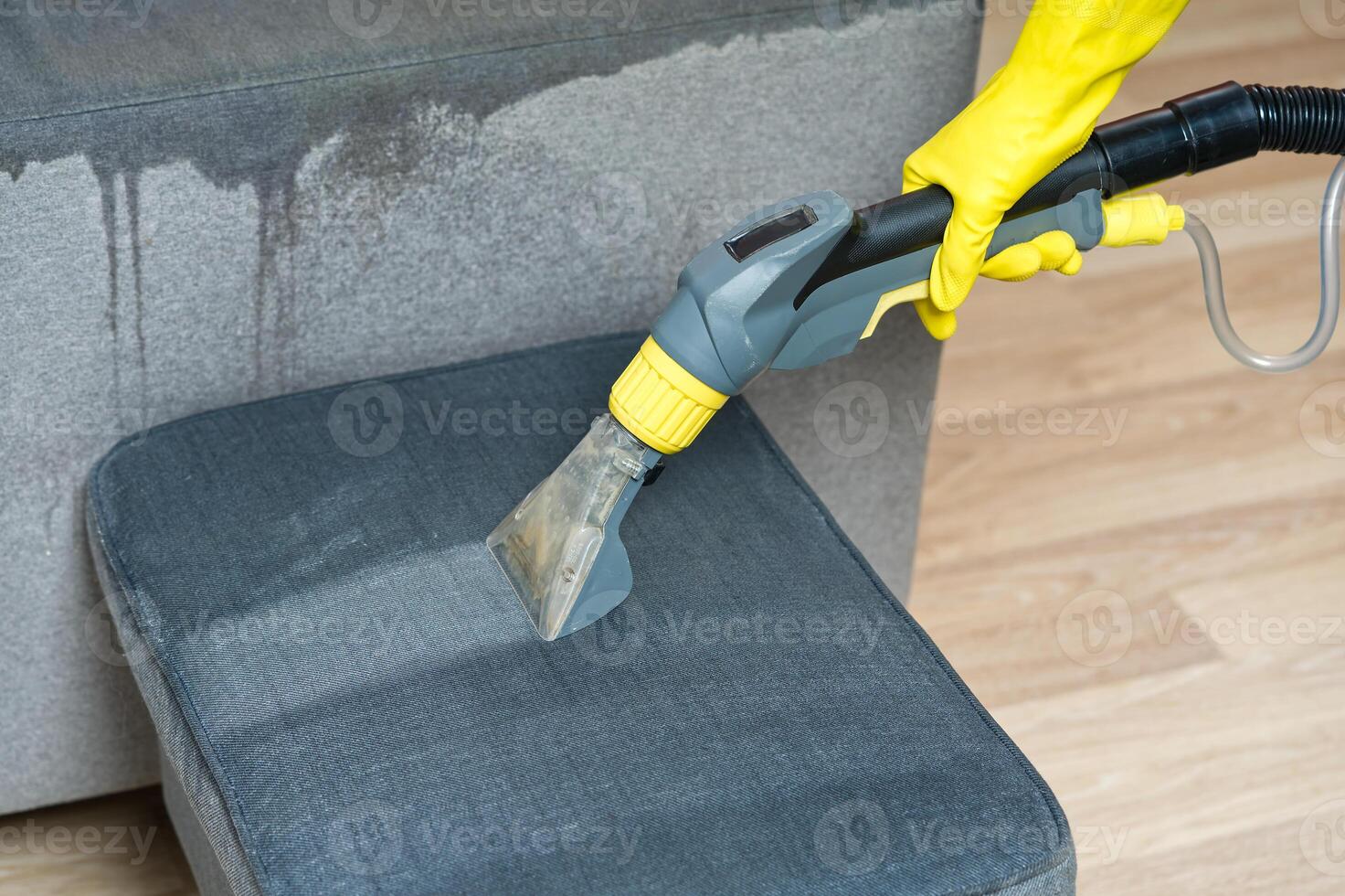Sofa chemical cleaning with professionally extraction method. Wet textile sofa cleaning. home cleaning service. cleaning sofa with washing suction cleaner closeup. photo