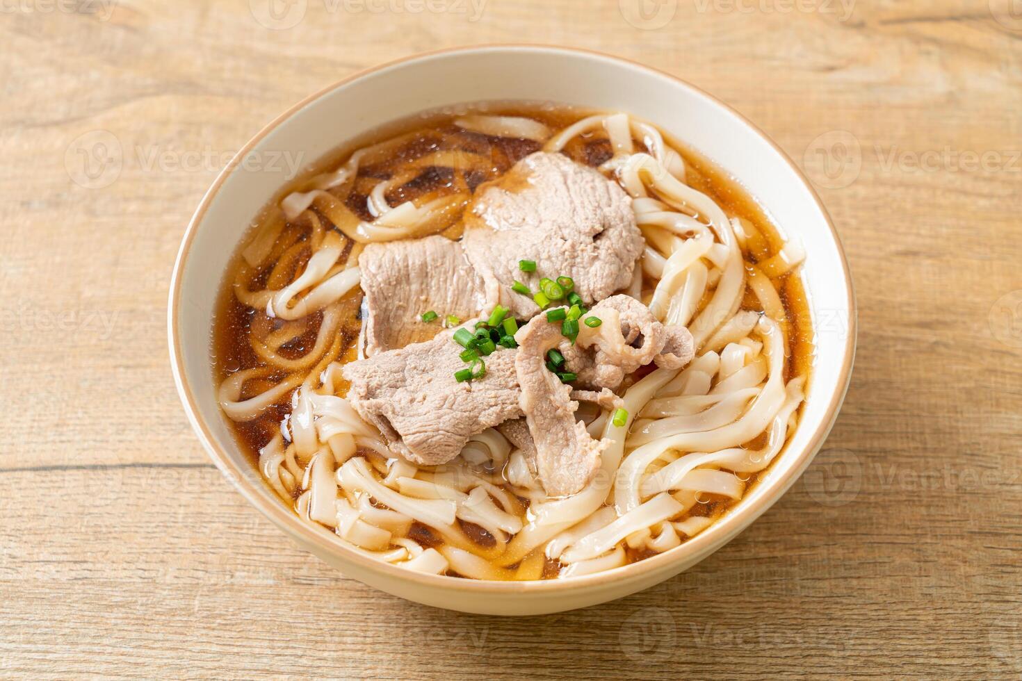 homemade udon noodles with pork in soy or shoyu soup in bowl photo