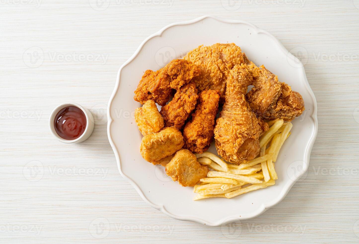 fried chicken with french fries and nuggets on white plate - unhealthy food style photo