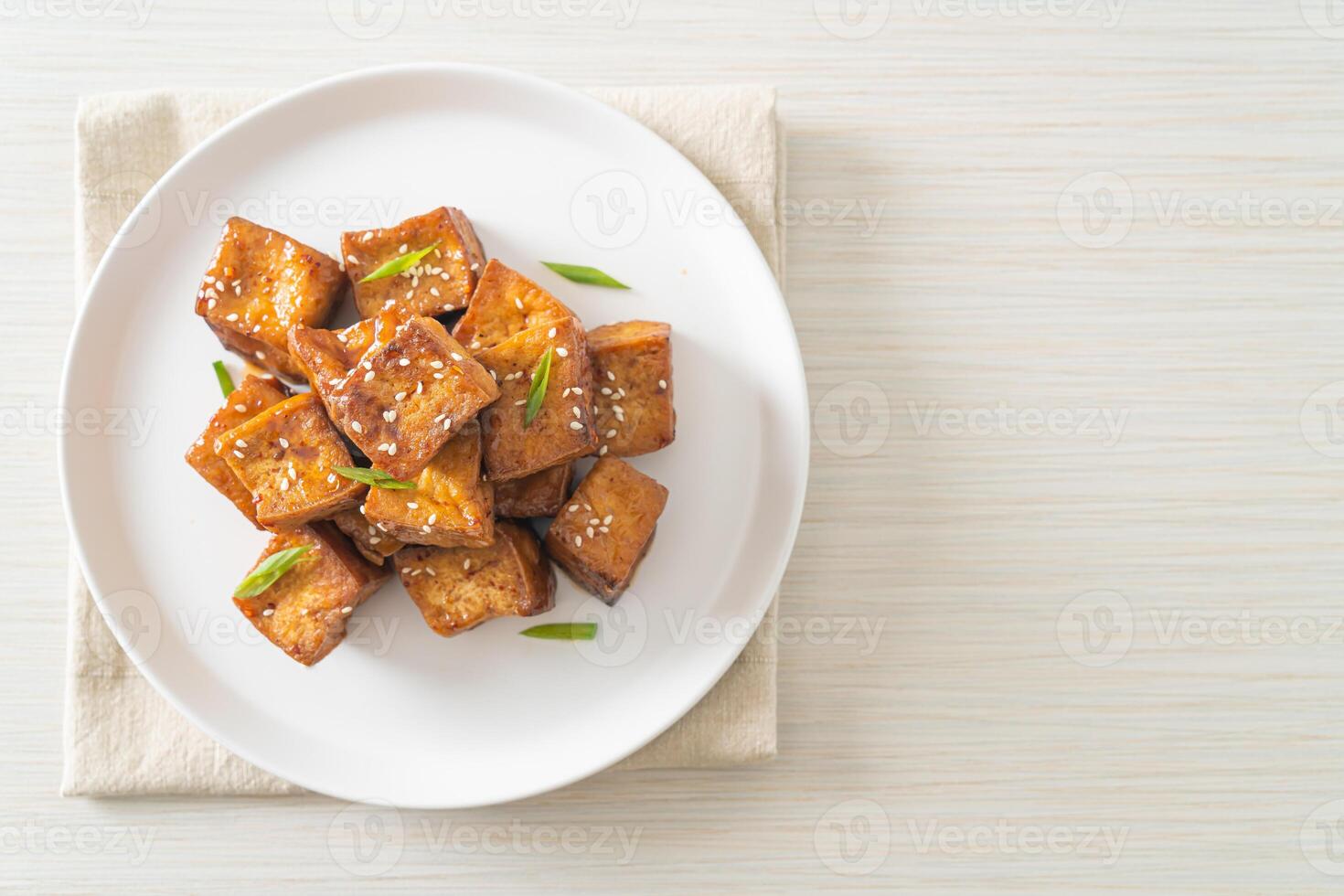 fried tofu with white sesame and teriyaki on plate photo