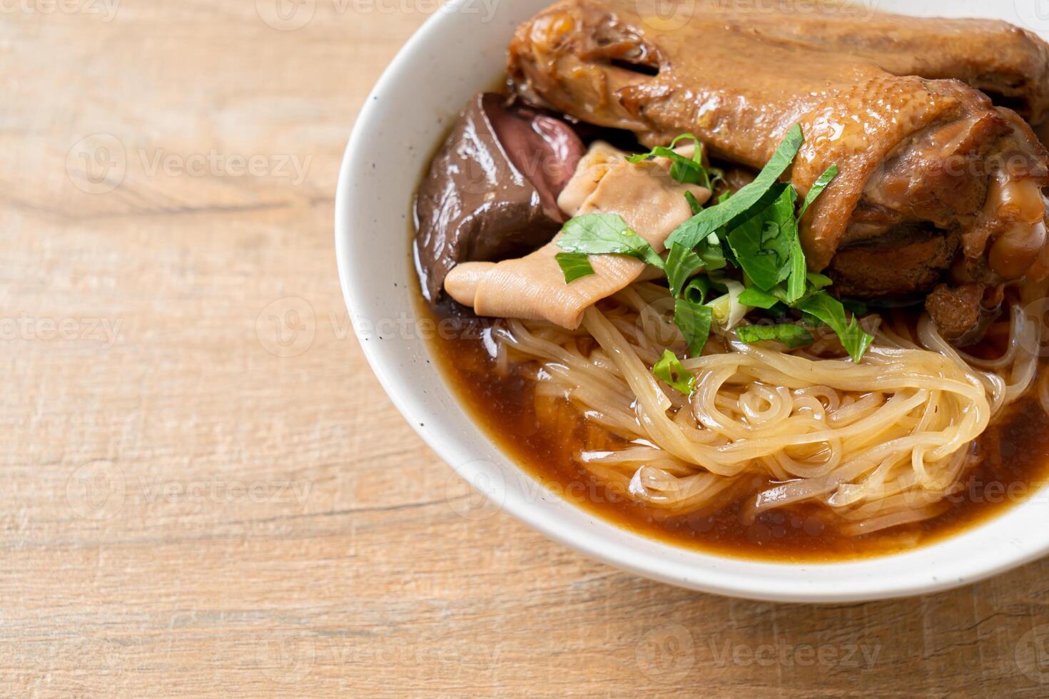 Braised duck noodles with brown soup in bowl photo