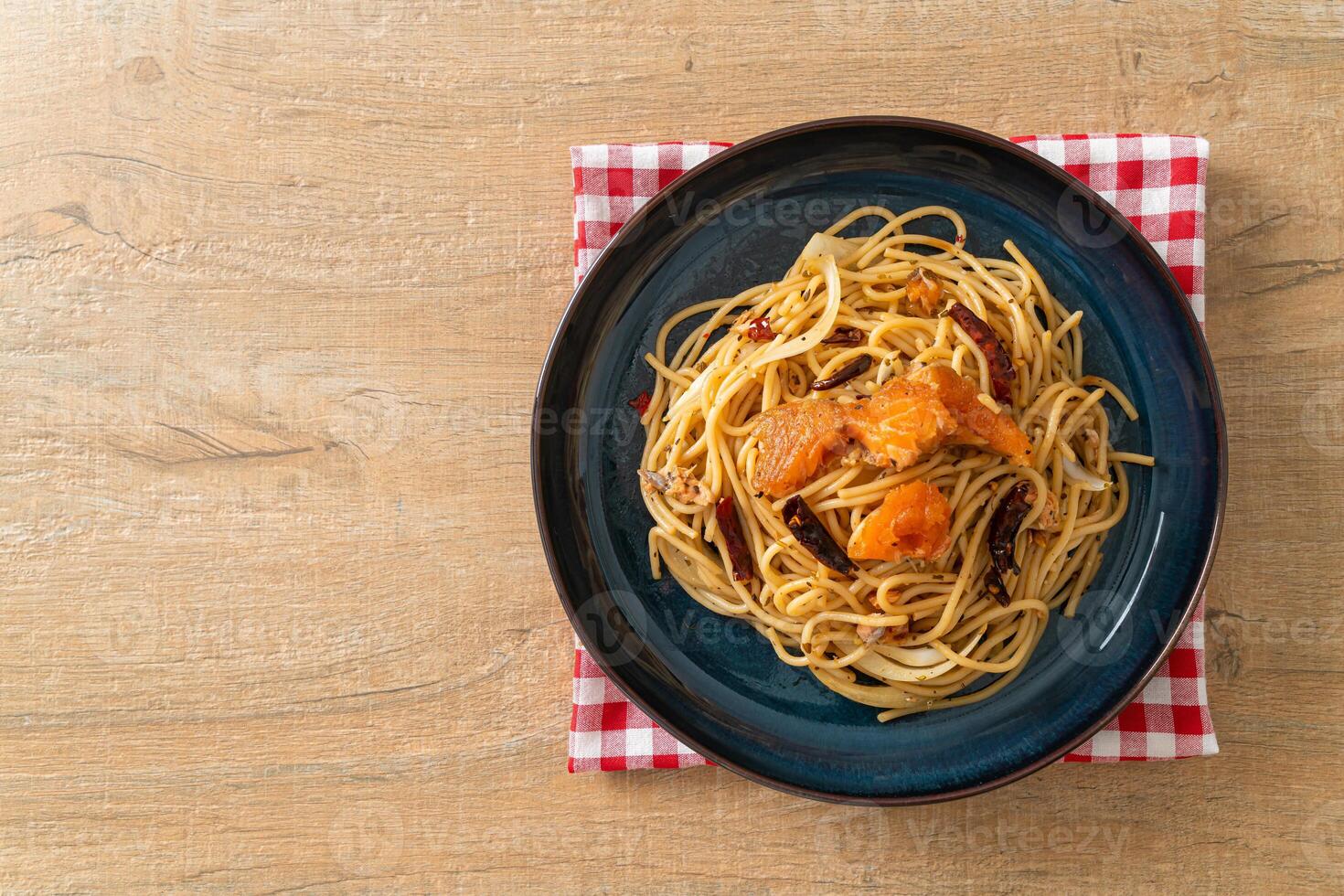 stir-fried spaghetti with salmon and dried chilli on plate photo