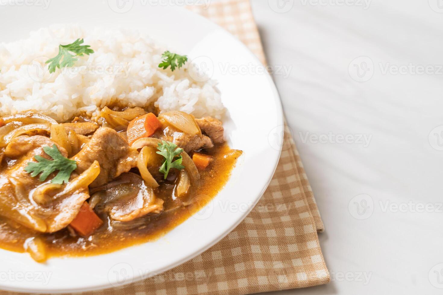 Japanese curry rice with sliced pork, carrot and onions on plate photo