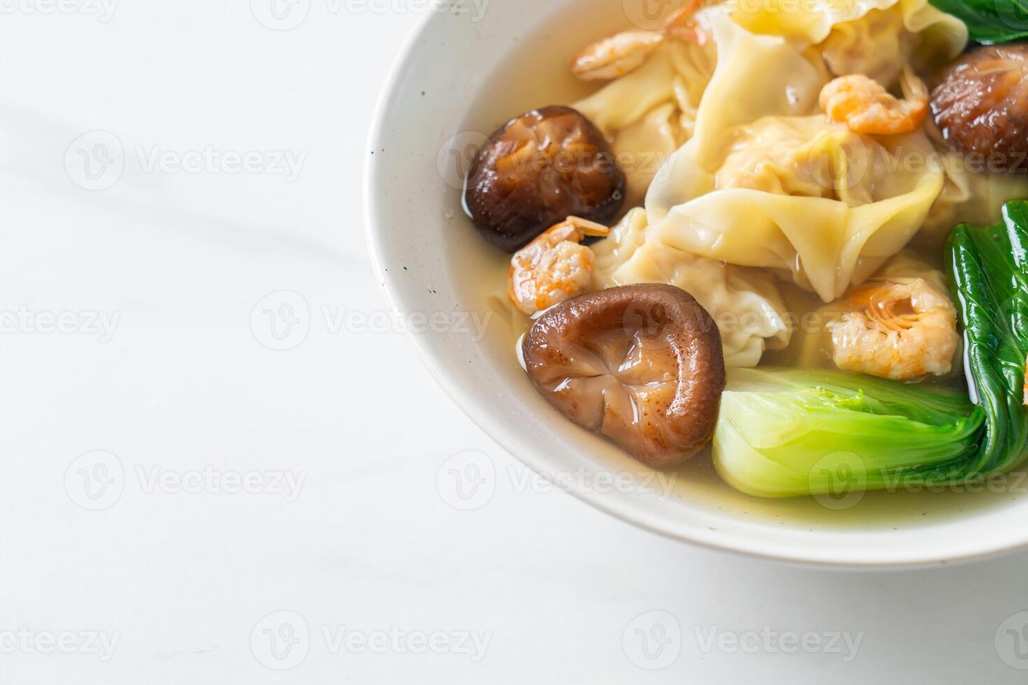 pork dumpling soup with shrimps and vegetable in bowl photo