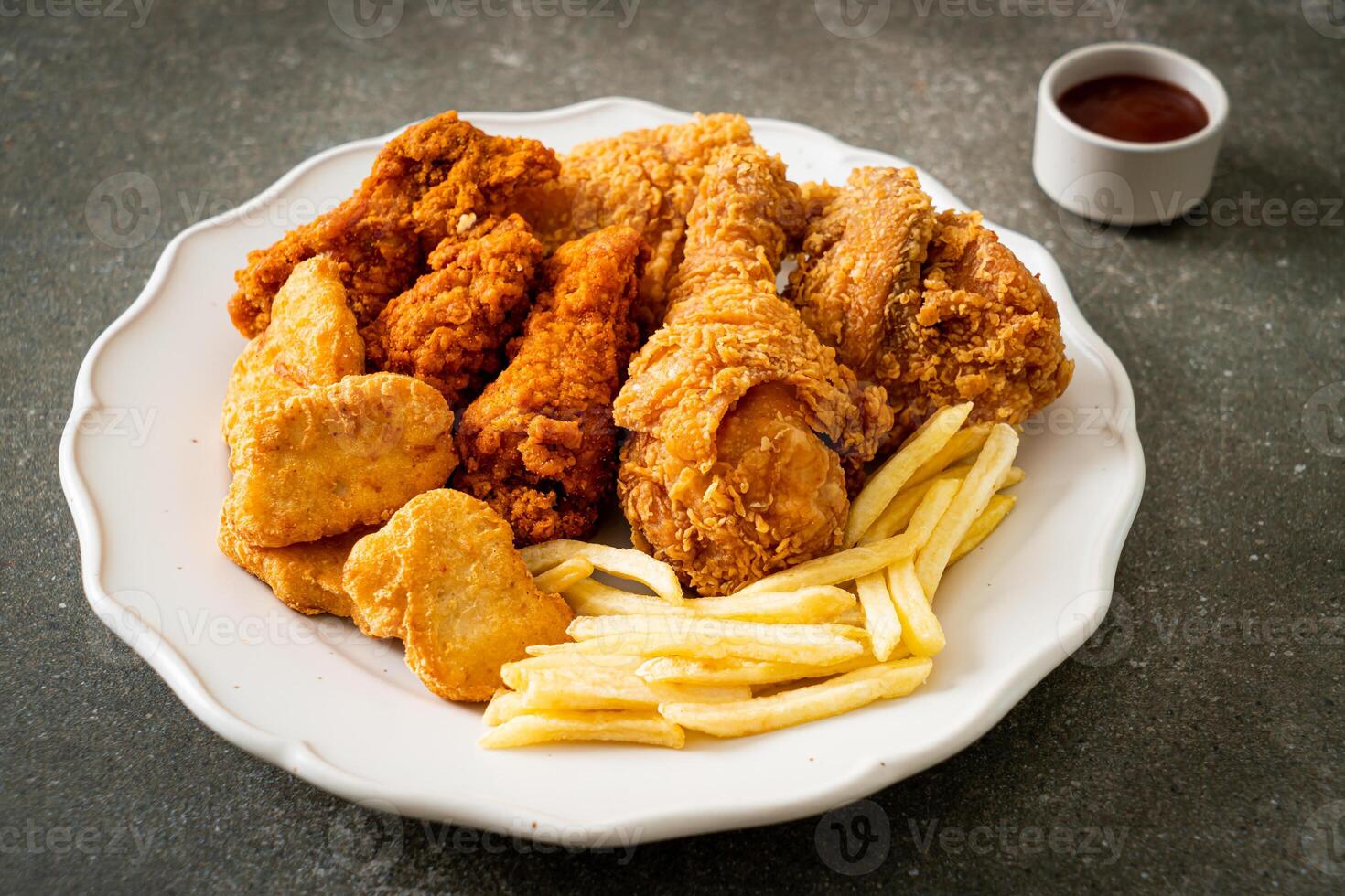 fried chicken with french fries and nuggets on white plate photo