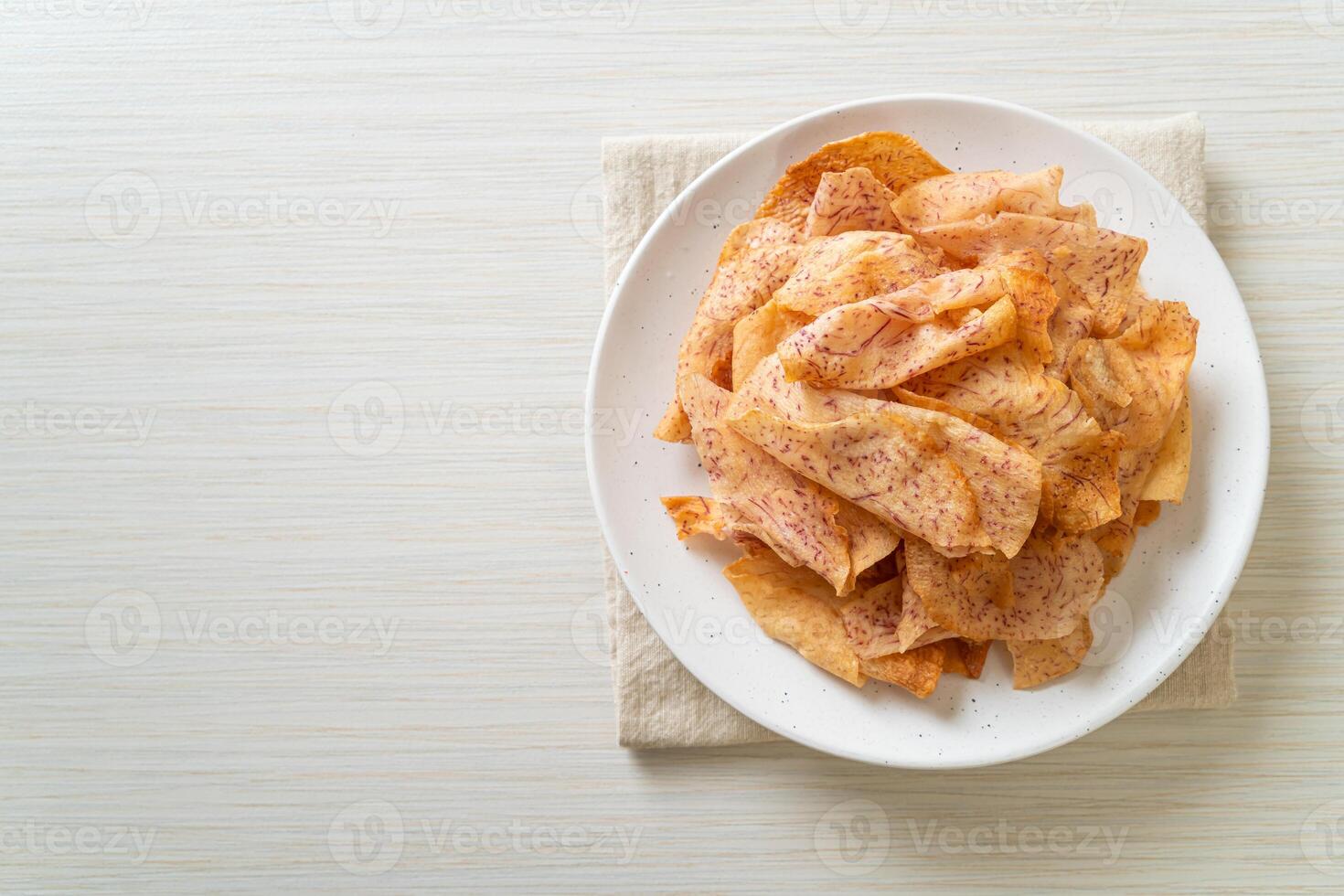 Taro Chips - fried or baked sliced taro on plate photo