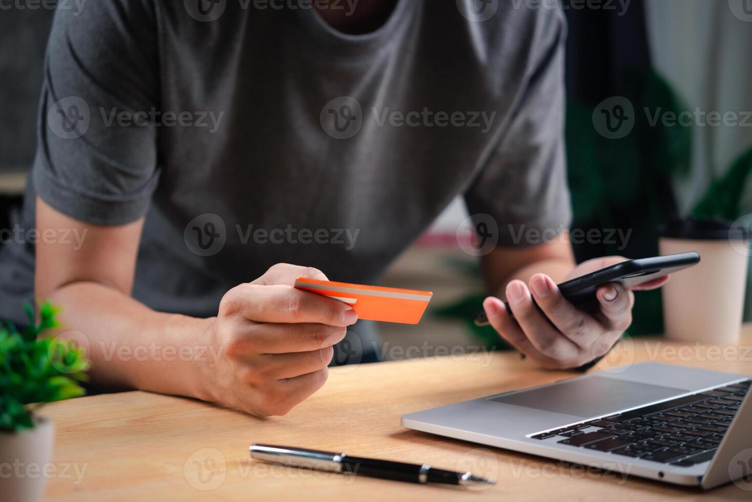 A man holding a credit card and a laptop photo
