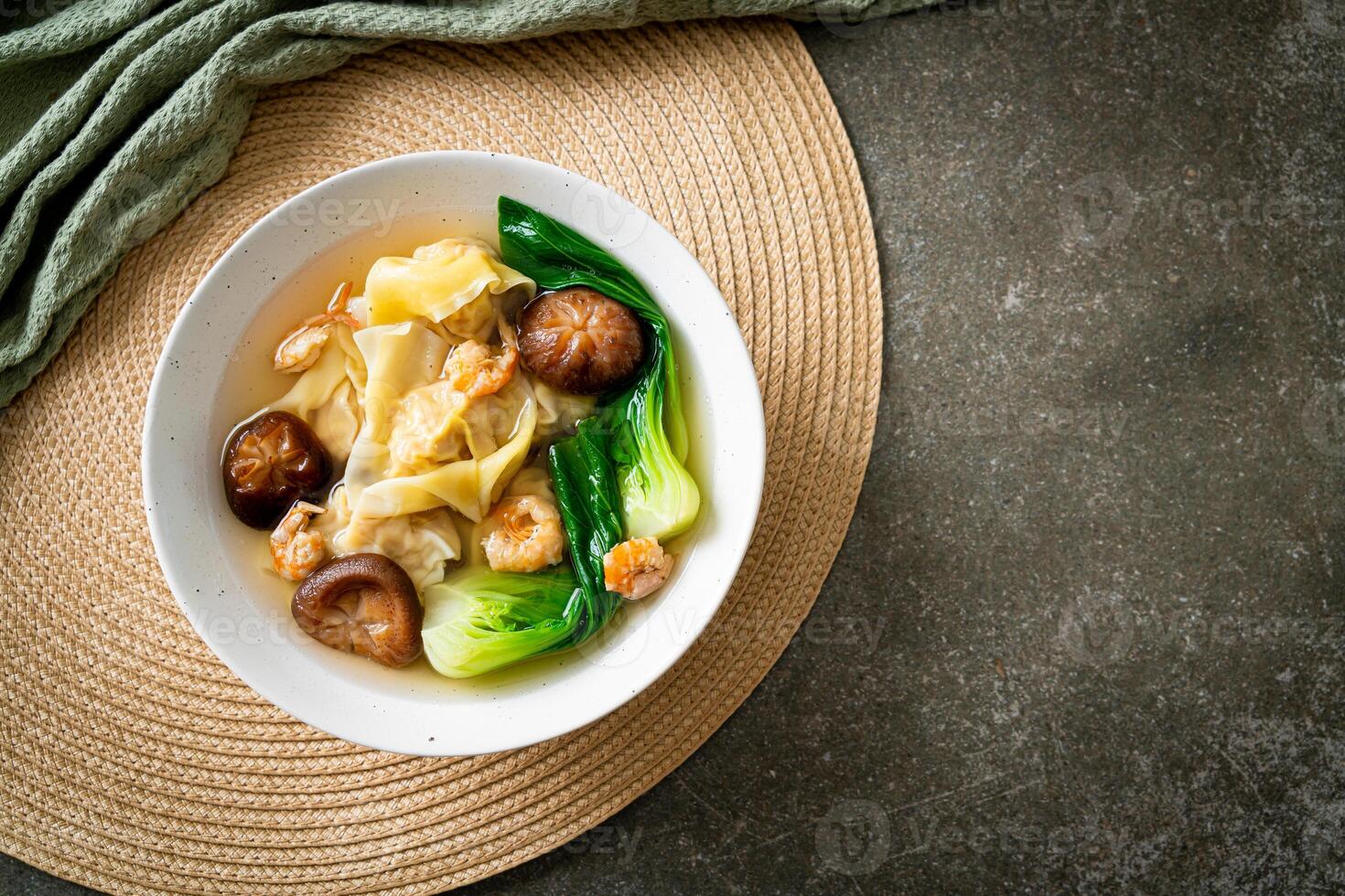 pork dumpling soup with shrimps and vegetable in white bowl photo