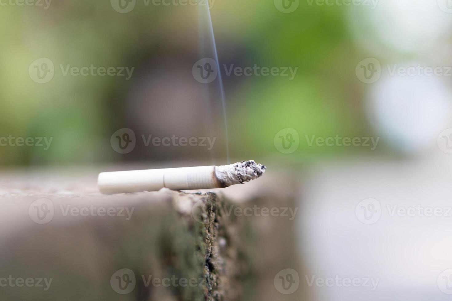 Close-up of a Burning Cigarette on Stone Surface photo