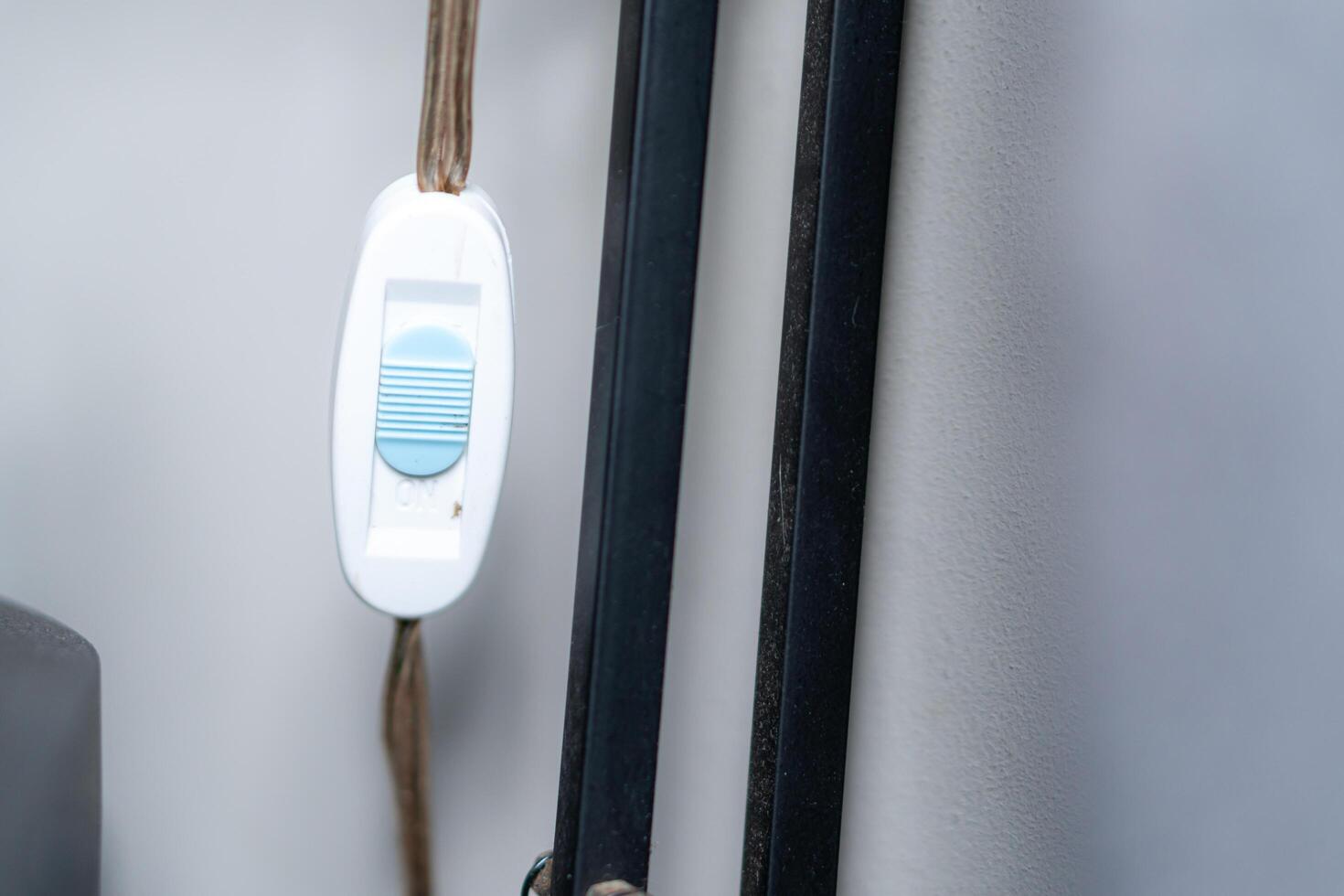 A white and blue cord attached to a wall photo