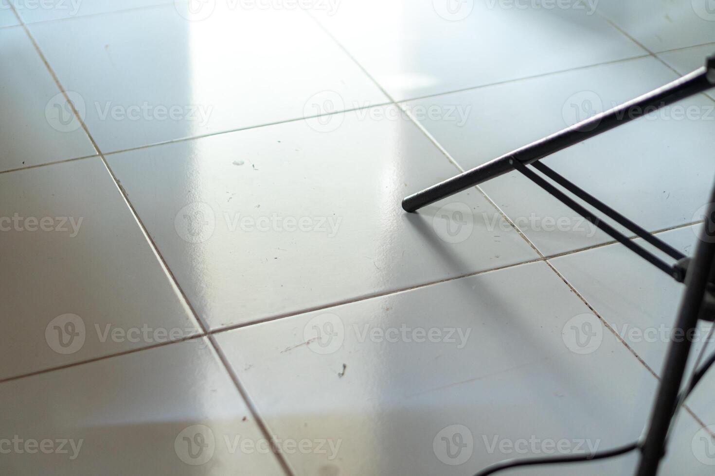 Close-Up of Tiled Floor with Chair Leg photo