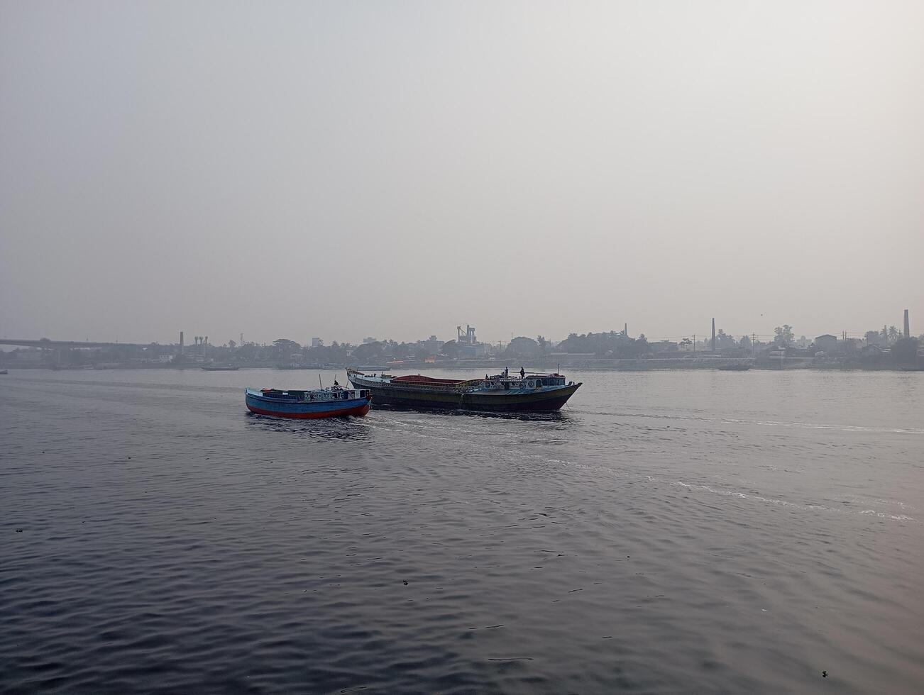 two boats floating on the water in front of a city photo