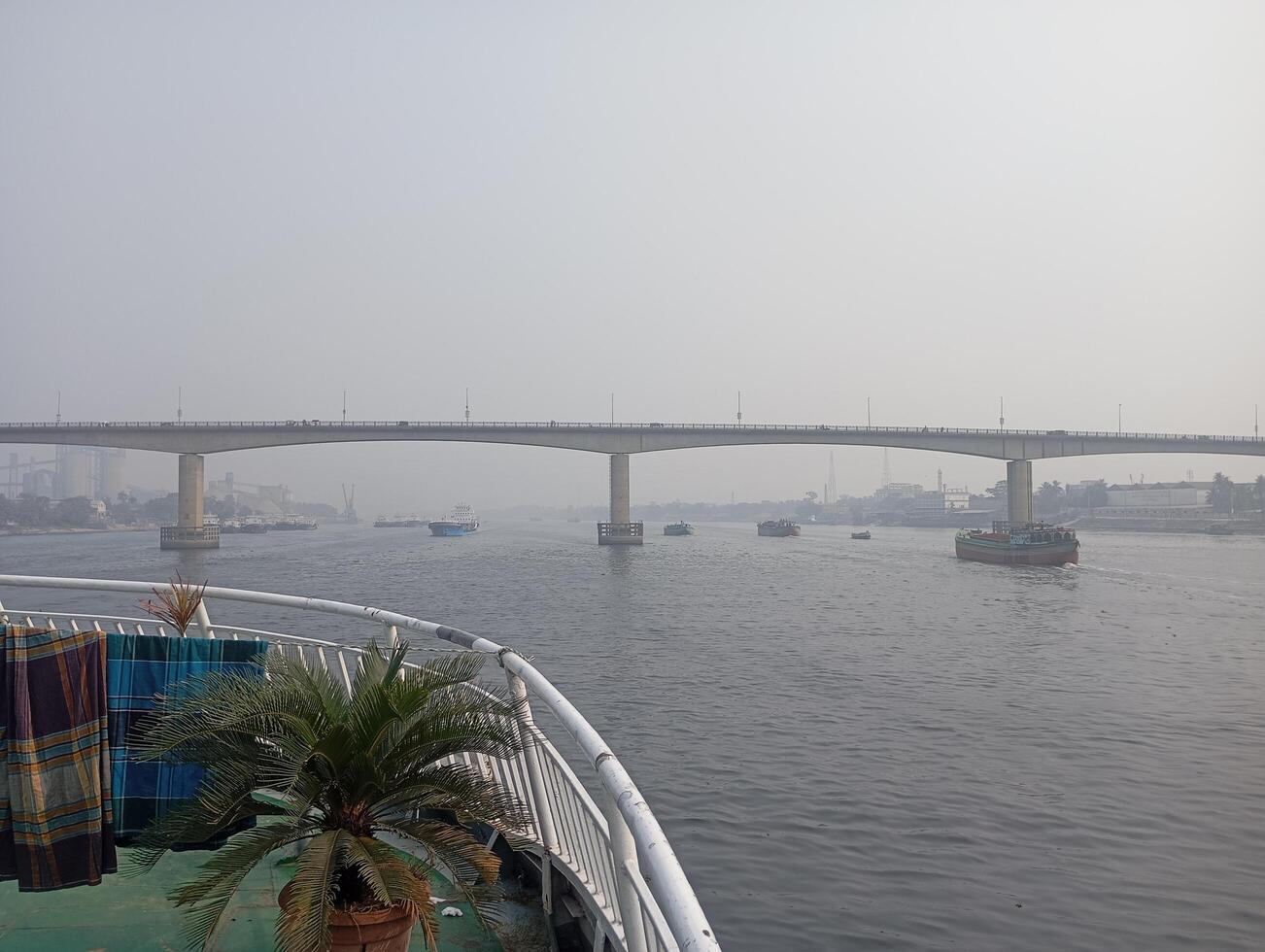 a boat on the river with a bridge in the background photo