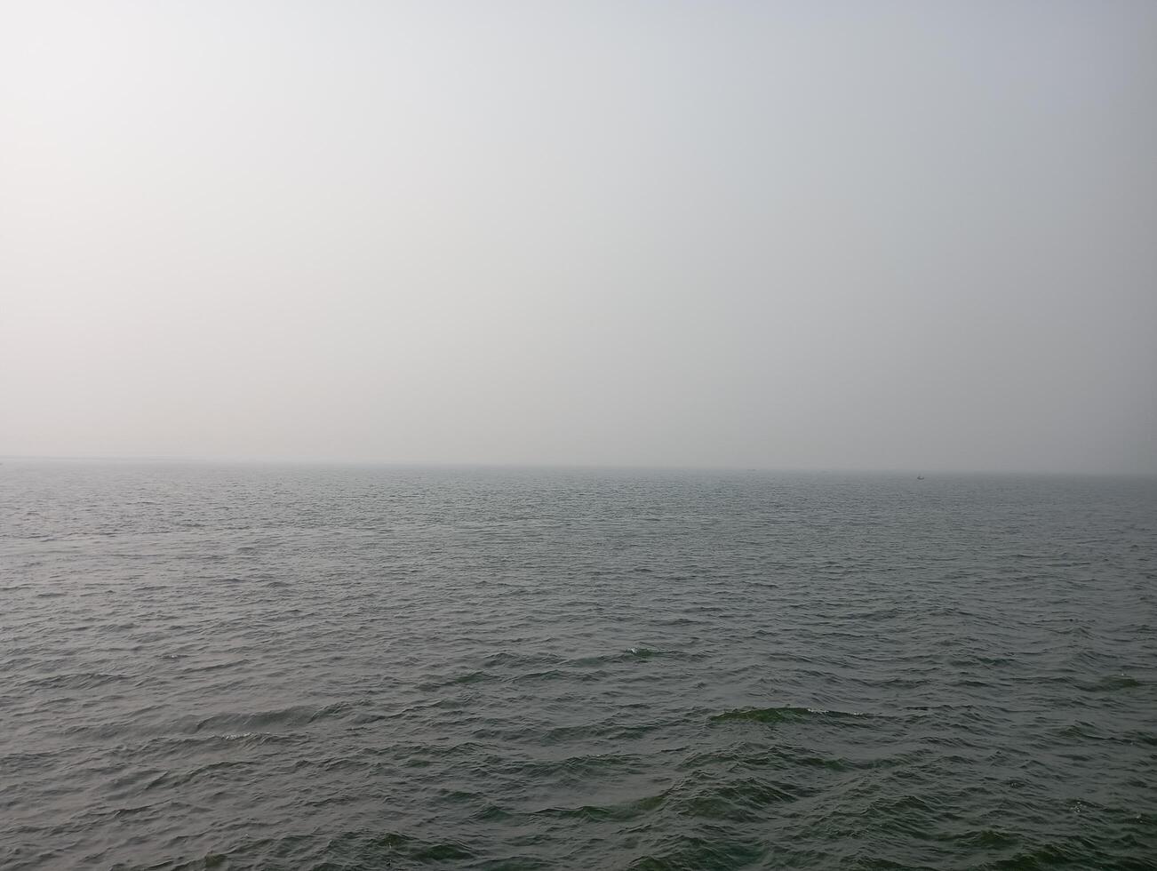 a boat is sailing in the ocean on a cloudy day photo