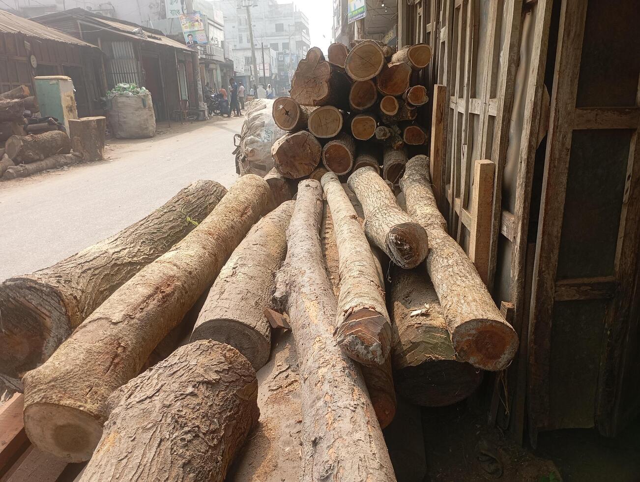 a pile of logs on the street in front of a building photo