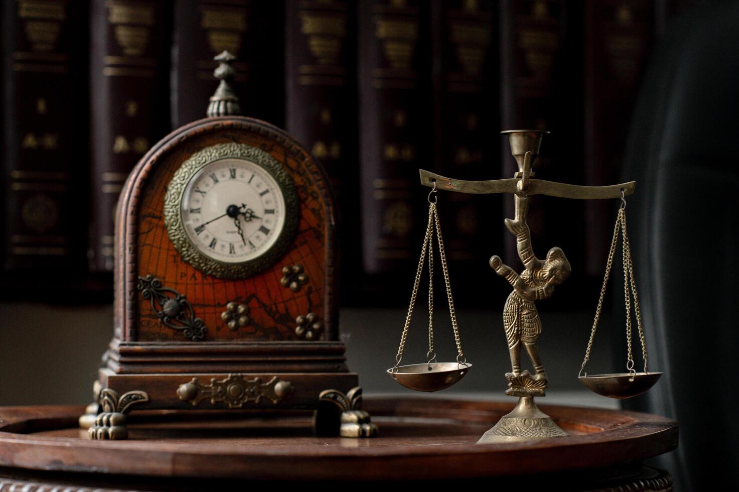 A sophisticated law office with a vintage desk clock and a carefully placed scales of justice statue, creating an atmosphere of legal expertise and timeless values. photo