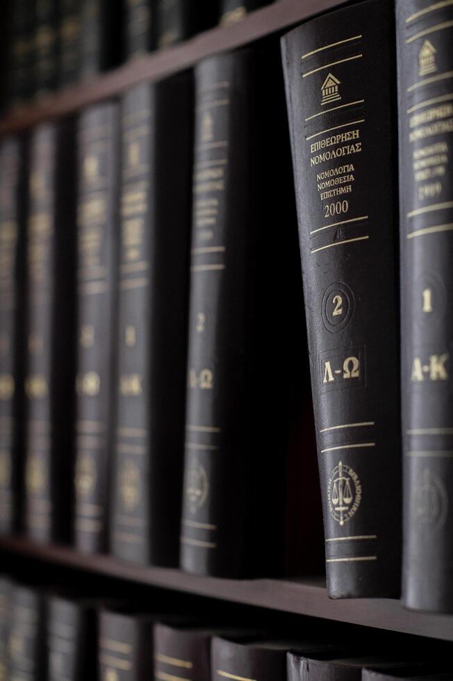 A well-organized bookshelf filled with books on law and jurisprudence, all written in Greek. photo