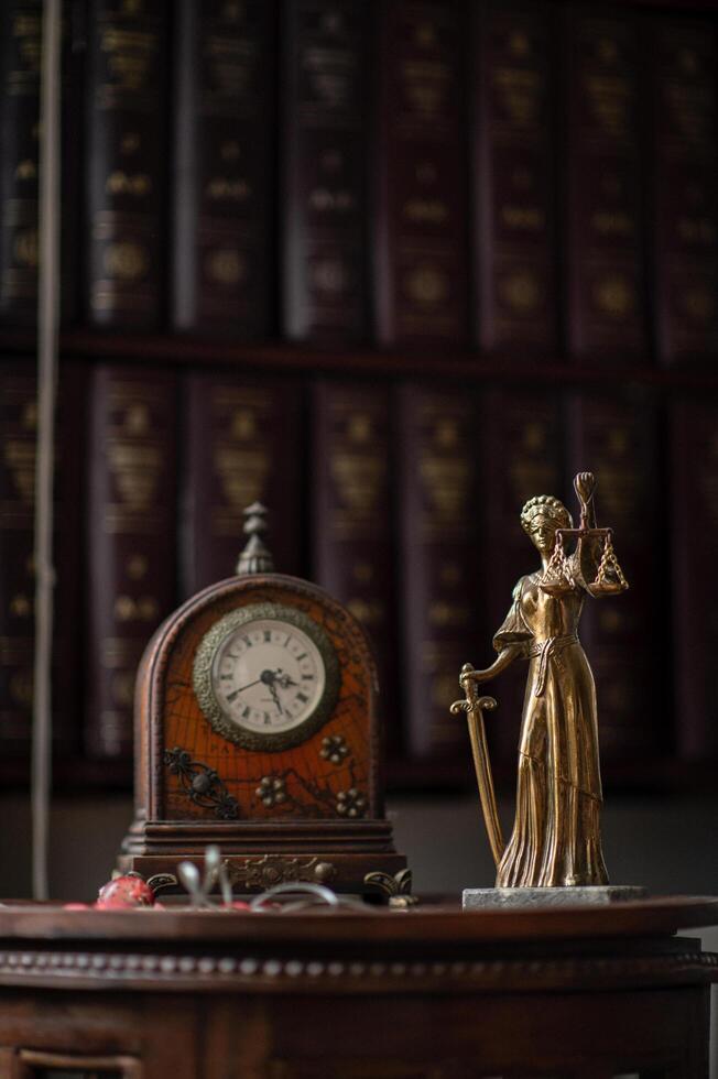 A well-organized legal office adorned with an antique clock and a bronze statue of Themis photo