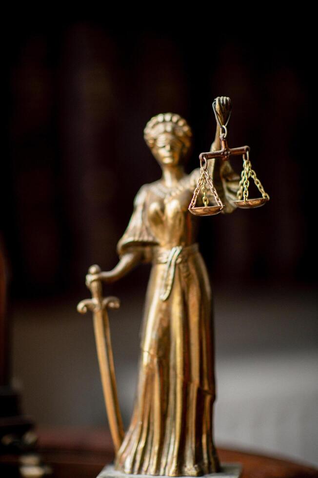 A refined law office with a vintage clock on a wooden shelf and a symbolic statue of Themis. photo