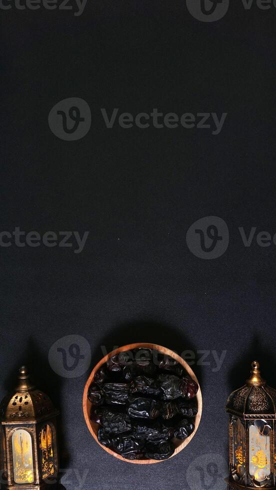 A Plate of Dates between Two Lanterns Decoration on Black Background photo