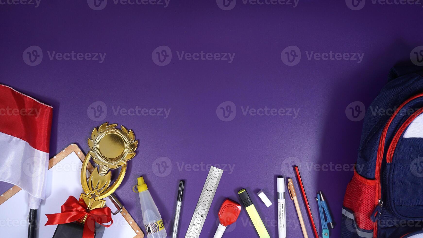 School Stationery with Backpack and Wooden Board Isolated on Purple Background photo