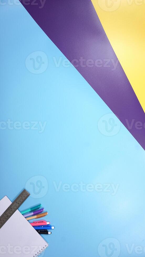 Various Color of Pens, Ruler, and Notebook on Colorful background photo