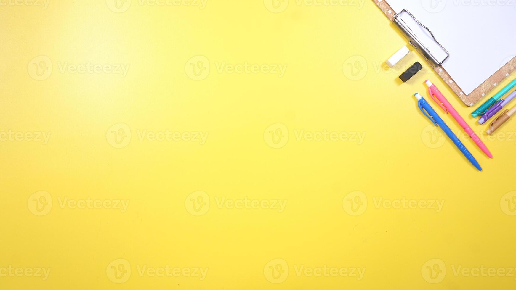 School Stationery and Wooden Clip Board on Yellow Background photo