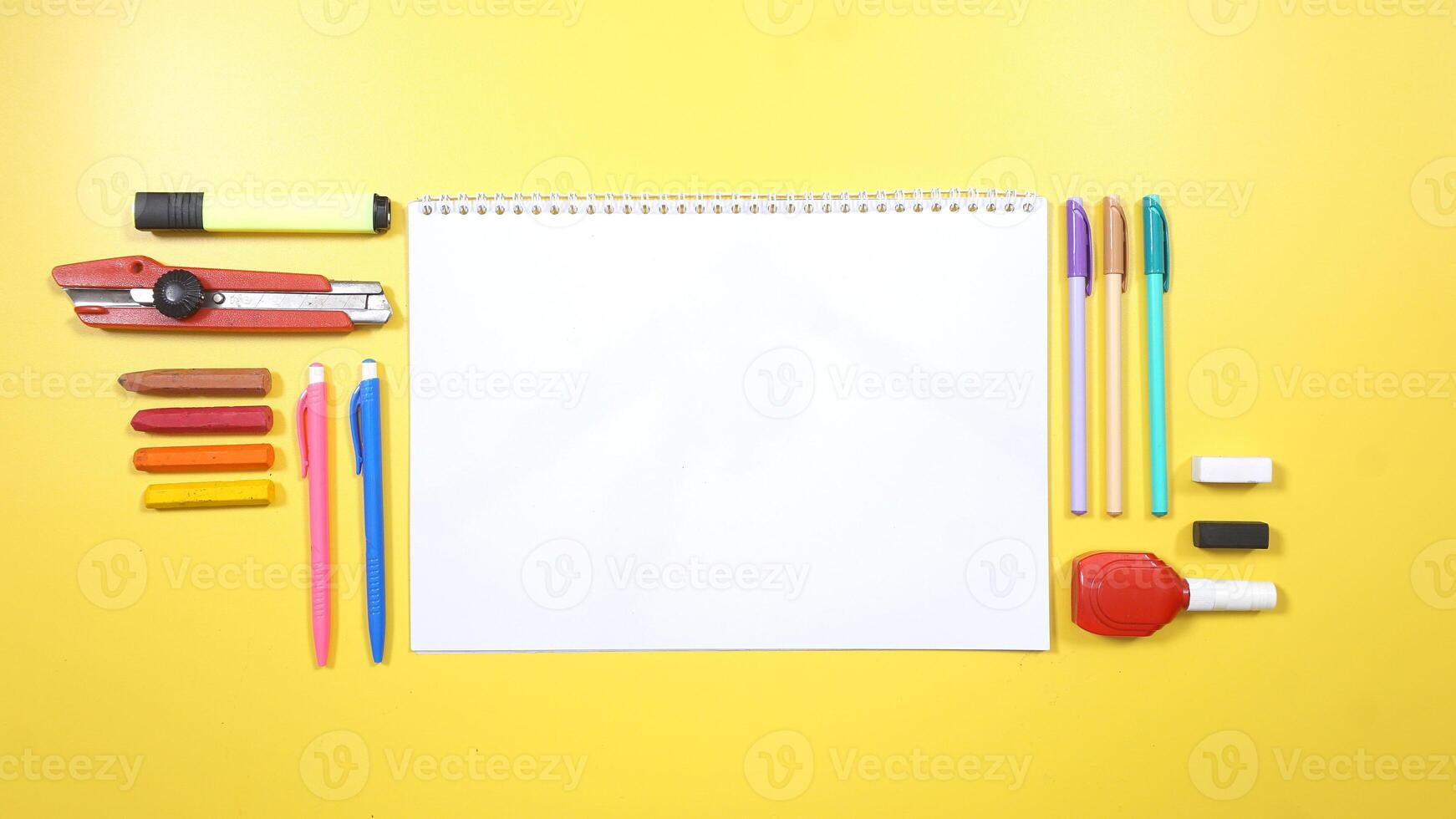 School Stationery and Notebook on Yellow Background photo