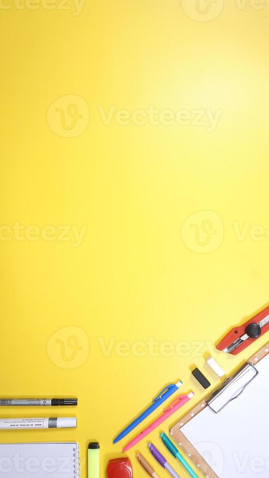 School Stationery, Notebook, and Wooden Clip Board on Yellow Background photo