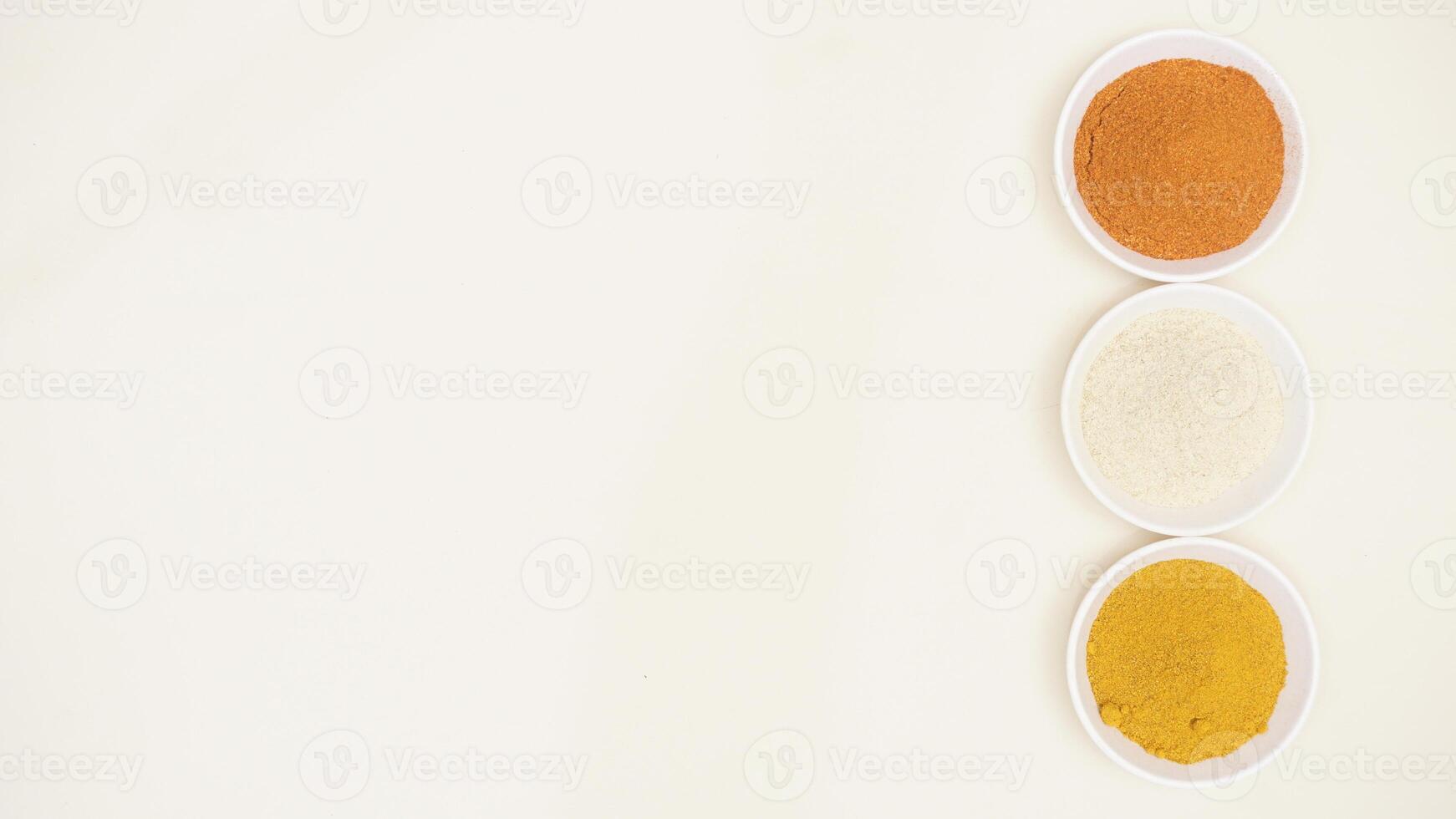 Various Spices Powder on Bowl with Copy Space on Light Background photo