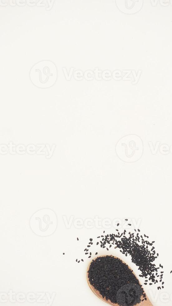 Black Cumin Spice on Wooden Spoon on Light Background photo