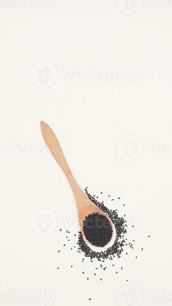 Black Cumin Spice on Wooden Spoon on Light Background with Copy Space photo