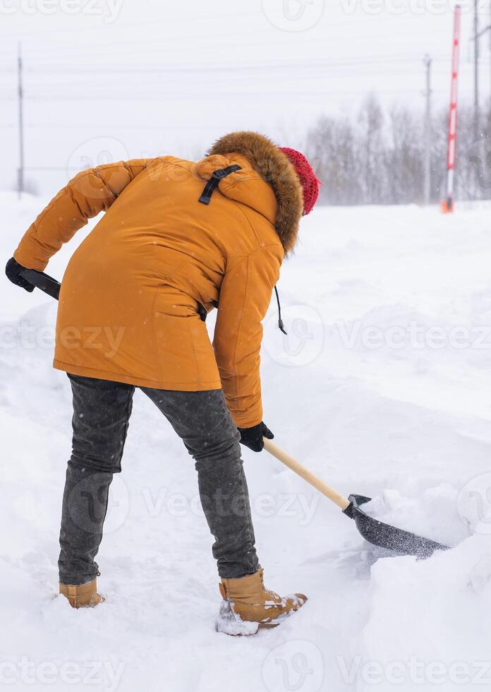 Man cleaning snow from sidewalk and using snow shovel. Winter season photo