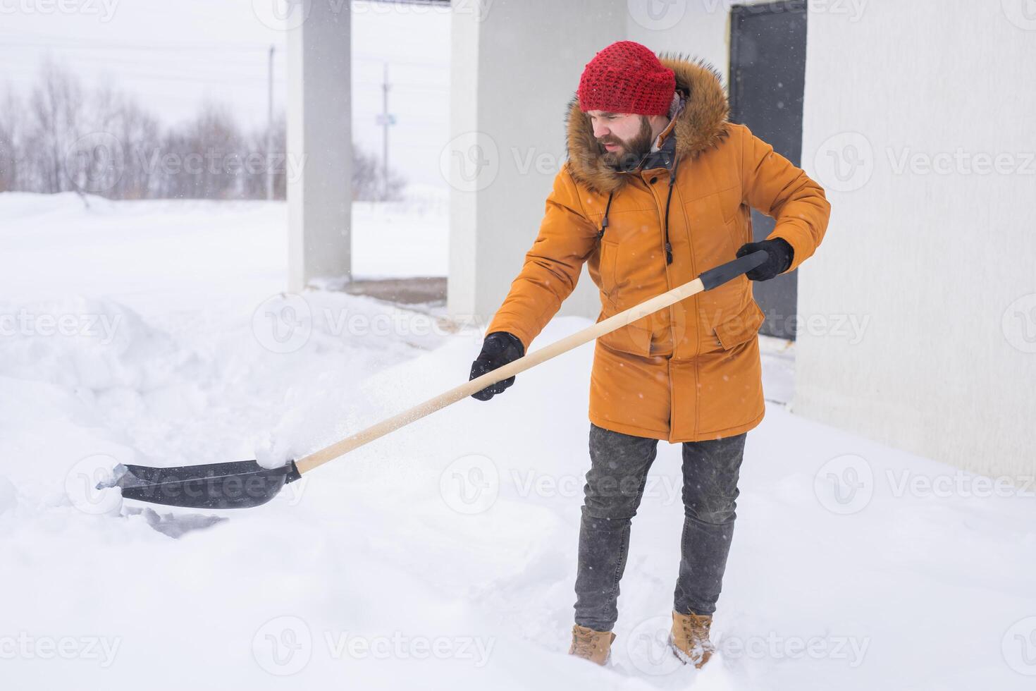 Man cleaning snow from sidewalk and using snow shovel. Winter season photo