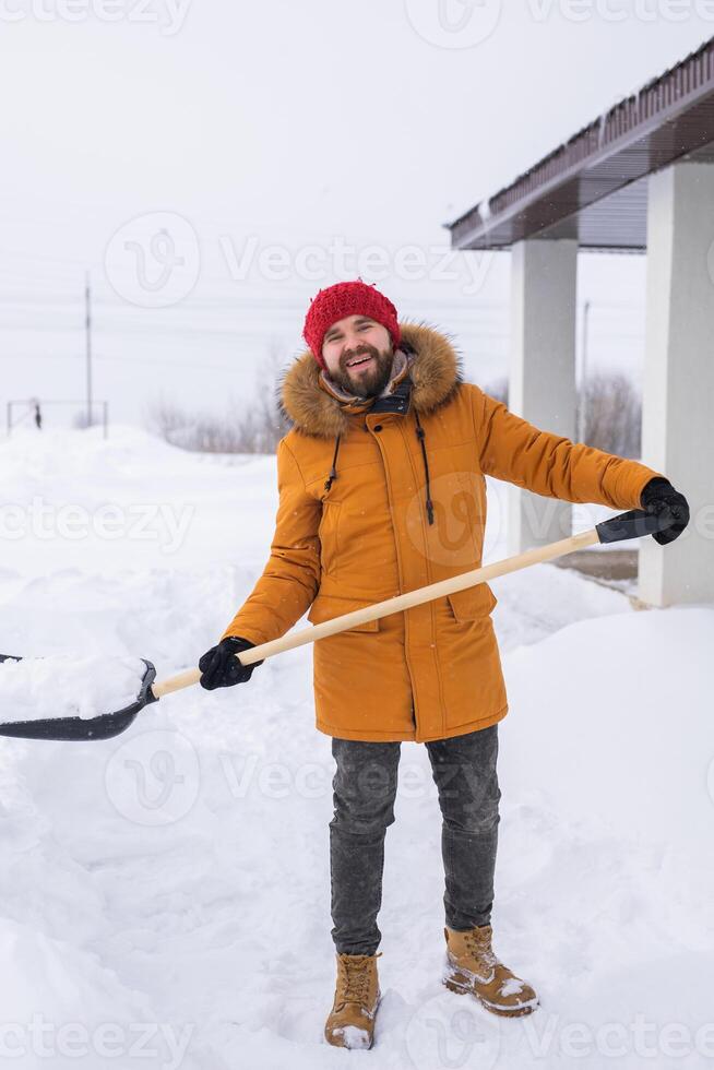 Man removing snow and ice from the sidewalk in front of house. Winter season photo