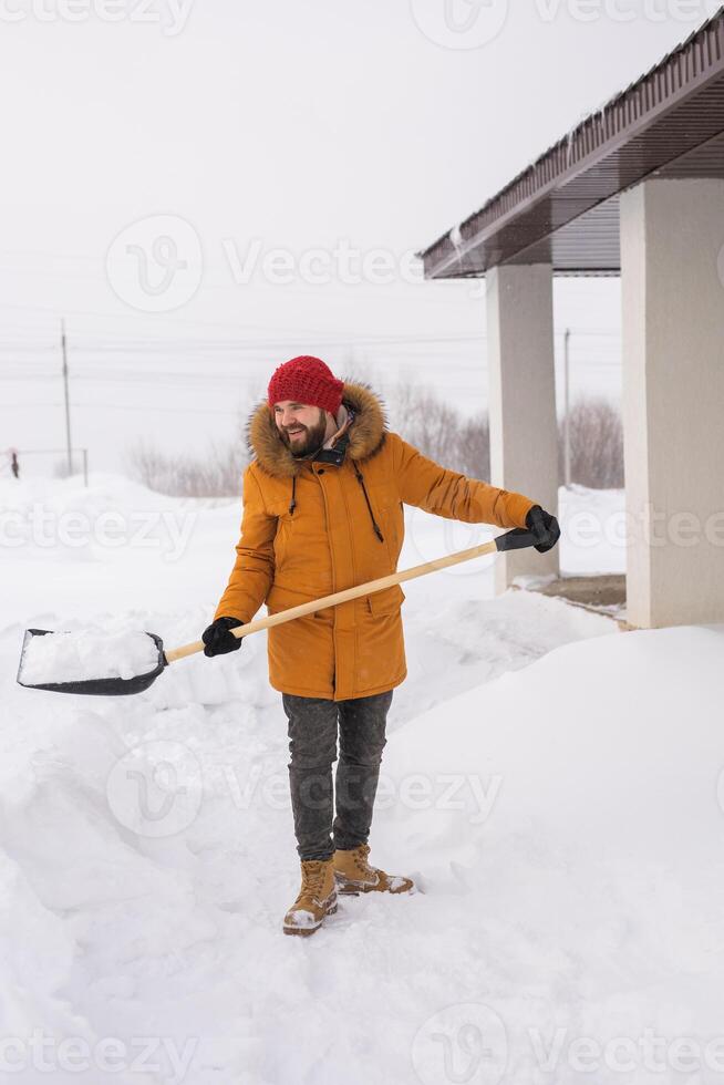 Man cleaning snow from sidewalk and using snow shovel. Winter season photo