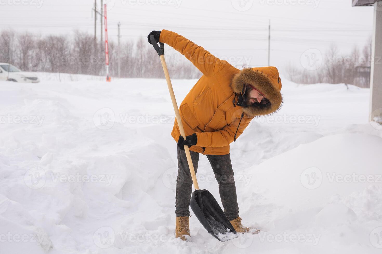 Man removing snow and ice from the sidewalk in front of house. Winter season photo